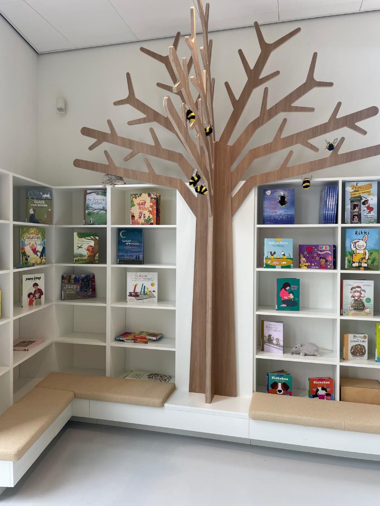 Tree bookshelf reading nook with wooden sculpture